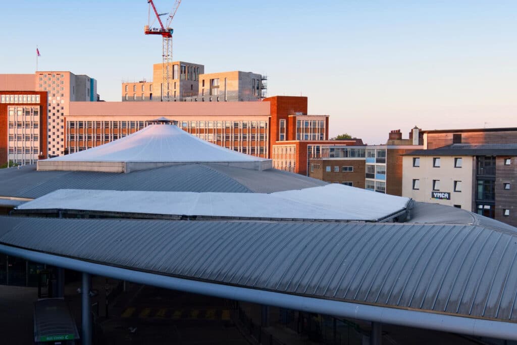 Toit moderne en métal sur un bâtiment situé dans une zone urbaine, entouré de gratte-ciels.